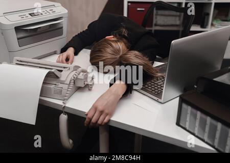 Donna d'affari stanca che dorme sul tavolo in ufficio. Concetto troppo lavorato. Foto Stock