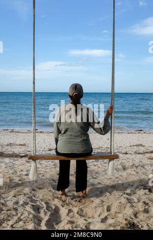 Donna che guarda all'oceano Foto Stock