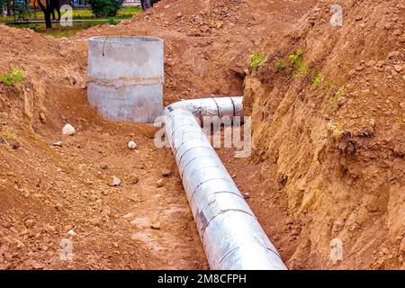 Installazione dell'unità di distribuzione della rete di riscaldamento e di alimentazione dell'acqua. Telaio per il collegamento di tubi nella trincea di terra. Foto Stock