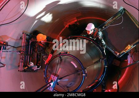 IL SENIOR AIRMAN Scott Fowler (top) e IL SENIOR AIRMAN Paul Gallegos, il personale addetto alla manutenzione con la 321st Strategic Missile Wing, guidano il sistema di rientro per i missili LGM-30 Minuteman III su un set di guida missilistica. Base: Grand Forks Air Force base Stato: North Dakota (ND) Paese: Stati Uniti d'America (USA) Foto Stock