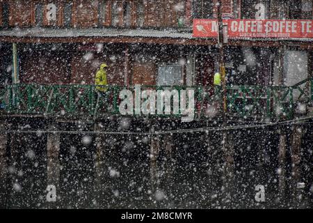 Srinagar, Kashmir, India. 13th Jan, 2023. Un uomo cammina lungo il ponte pedonale in legno durante le nevicate. Parti della valle di Kashmir compreso Srinagar ha ricevuto nevicate che portano alla chiusura della vitale Srinagar-Jammu autostrada nazionale e la cancellazione delle operazioni di volo, funzionari qui ha detto. (Credit Image: © Saqib Majeed/SOPA Images via ZUMA Press Wire) SOLO PER USO EDITORIALE! Non per USO commerciale! Foto Stock