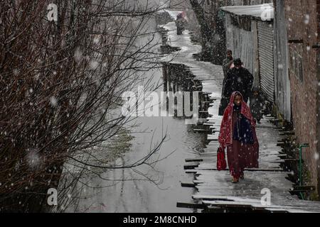 Srinagar, Kashmir, India. 13th Jan, 2023. I residenti camminano lungo il ponte pedonale in legno durante le nevicate. Parti della valle di Kashmir compreso Srinagar ha ricevuto nevicate che portano alla chiusura della vitale Srinagar-Jammu autostrada nazionale e la cancellazione delle operazioni di volo, funzionari qui ha detto. (Credit Image: © Saqib Majeed/SOPA Images via ZUMA Press Wire) SOLO PER USO EDITORIALE! Non per USO commerciale! Foto Stock