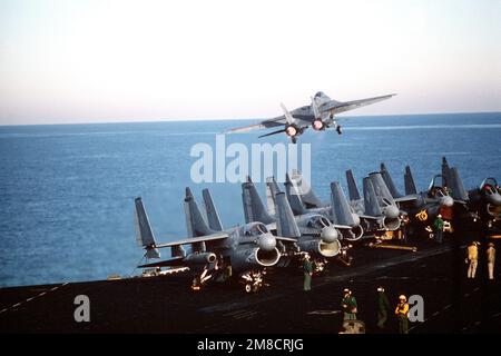 Un aereo Fighter Squadron 14 (VF-14) F-14A Tomcat decolve dal ponte di volo della portaerei USS JOHN F. KENNEDY (CV-67 durante la flotta ex 1-90. A-7E gli aerei Corsair II dell'attacco Squadron 46 (VA-46) e dell'attacco Squadron 72 (VA-72) sono parcheggiati sul ponte di volo. Il Corsair all'estrema sinistra è dotato di Tactical Air Reconnaissance pods (TARPE). Oggetto/Serie: FLOTTA EX 1-90 base: USS John F. Kennedy (CV 67) Paese: Oceano Atlantico (AOC) Foto Stock