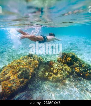 Immersioni ragazzi adolescenti snorkeling sopra le barriere coralline foto subacquea nella laguna turchese pulita sulla spiaggia di le Morne. Isola Mauritius. Viaggio esotico Foto Stock