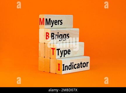 Simbolo indicatore tipo MBTI Myers Briggs. Concetto parole MBTI Myers Briggs tipo indicatore su blocco su bellissimo sfondo arancione. MBTI psicologico mio Foto Stock