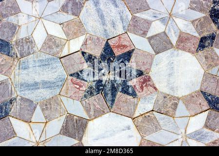Piastrelle in marmo d'epoca grigio in ceramica sfondo testurizzato sul vecchio edificio pietra muro in mattoni primo piano. Foto Stock