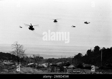 Tre elicotteri Marine Corps CH-53 Sea Stallion, accompagnati da due elicotteri AH-1 Sea Cobra, a sinistra e al secondo da destra, si avvicinano ad una zona di atterraggio vicino alla costa durante l'esercizio combinato South Korean/U.S. Team Spirit '90. Soggetto operativo/Serie: TEAM SPIRIT '90 Paese: Repubblica di Corea (KOR) Foto Stock