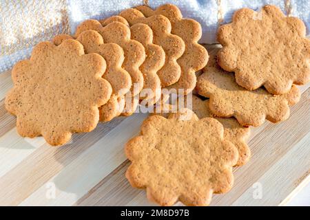 Tini di mandorle dolci svedesi con zenzero e cannella (biscotti Pepparkaka o Pepparkakor) su fondo di legno chiaro. Foto Stock