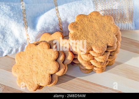 Tini di mandorle dolci svedesi con zenzero e cannella (biscotti Pepparkaka o Pepparkakor) su fondo di legno chiaro. Foto Stock