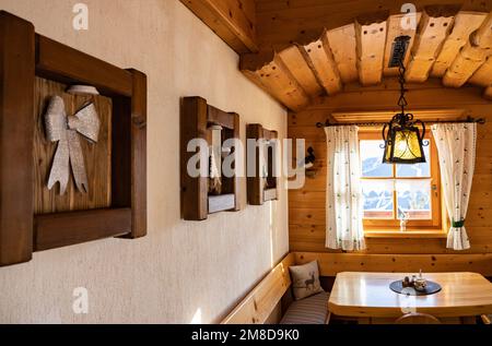 Pareti splendidamente decorate vicino alla finestra in un accogliente ristorante austriaco nella stazione sciistica Foto Stock