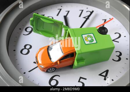 MODELLO DI AUTO IN BIDONE DI RICICLAGGIO SU OROLOGIO FACCIA RI RICICLAGGIO AUTO EMISSIONI ELETTRICHE DRIVER CARBURANTE DIESEL BENZINA TEMPO ESAURITO ECC UK Foto Stock