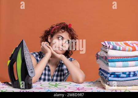 Una giovane donna si sguardi ad un mucchio piegato di asciugamani stirati e profumati. Foto Stock