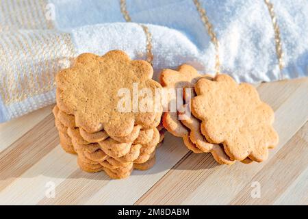 Tini di mandorle dolci svedesi con zenzero e cannella (biscotti Pepparkaka o Pepparkakor) su fondo di legno chiaro. Foto Stock