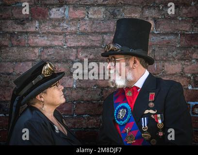 Ritratto di uno steampunk maschio e femmina che guarda gli occhi gli uni verso gli altri. Coppia steampunk innamorata, faccia a faccia. Ritratto dei vecchi punzoni a vapore. Foto Stock