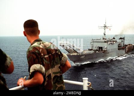 Marines guardare da un altro Stati Uniti Navy come la nave di atterraggio del carro armato USS SCHENECTADY (LST-1185) passa la loro nave in rotta verso il Medio Oriente a sostegno dell'operazione Desert Shield. Soggetto operazione/Serie: SCUDO DEL DESERTO Paese: Sconosciuto Foto Stock