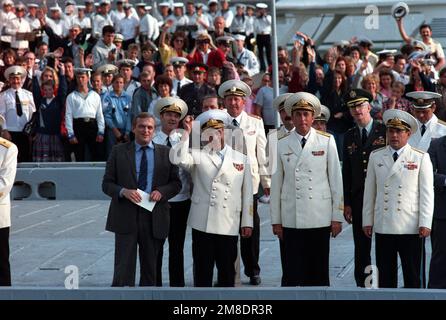 Ammiraglio Gennadi Khvatov, prima fila, secondo da sinistra, comandante, flotta del Pacifico sovietico, Alza la mano in benvenuto mentre lui e un partito ufficiale assistono all'arrivo di due navi della Marina statunitense. L'incrociatore missilistico guidato USS PRINCETON (CG 59) e la fregata missilistica guidata USS REUBEN JAMES (FFG 57) sono venuti a Vladivostok per una visita di quattro giorni. Base: Vladivostok Stato: Siberia Nazione: U.S.R. (DOM) Foto Stock