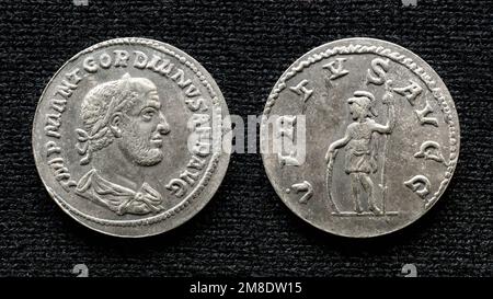 Antica moneta romana dell'imperatore Gordino III Vecchio denaro raro, argento denario isolato su sfondo scuro, macro. Concetto di Roma, impero, moneta preziosa, Foto Stock