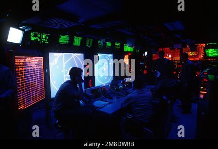 I membri dell'equipaggio controllano le attrezzature nel centro di informazioni sul combattimento della portaerei a energia nucleare USS ABRAHAM LINCOLN (CVN-72). Paese: Mar dei Caraibi Foto Stock