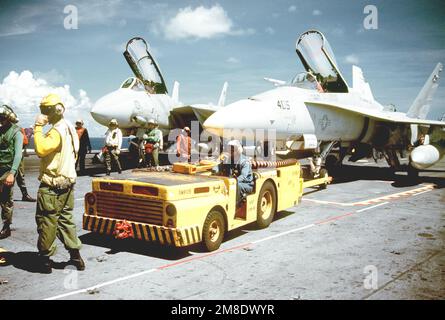 Gli equipaggi della piattaforma di volo a bordo della portaerei nucleare USS ABRAHAM LINCOLN (CVN-72) si preparano a rimpiazzare un aereo da combattimento Squadron 305 (VFA-305) F/A-18A Hornet. Un aereo Fighter Squadron 113 (VF-113) F-14A Tomcat è a sinistra. Paese: Mar dei Caraibi Foto Stock