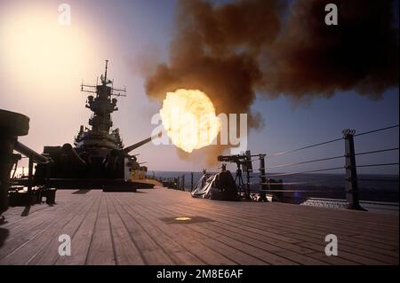 Un proiettile viene sparato dal lato del porto da uno dei cannoni Mark da 7 16 pollici/50-calibro nella torretta n. 2 a bordo della nave da guerra USS WISCONSIN (BB-64). La nave viene dispiegata nel golfo per sostenere l'operazione Desert Shield. Soggetto operazione/Serie: SCUDO DEL DESERTO Paese: Sconosciuto Foto Stock