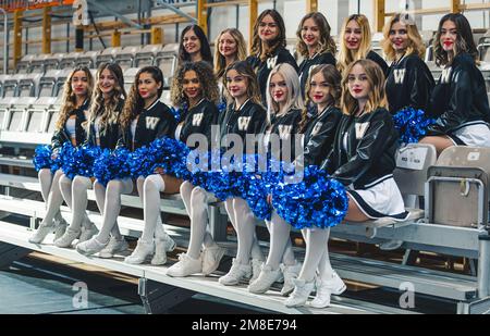 Cheerleaders in mini-gonne seduta su sedie in posa per la macchina fotografica e tenendo pom-pom. Foto Stock