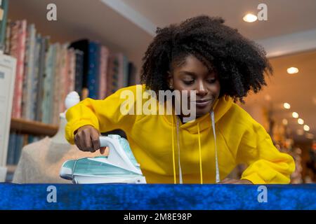 Ragazza afro-americana nel suo laboratorio di cucito. Foto Stock