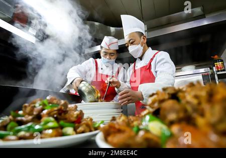 ZHANGYE, CINA - 13 GENNAIO 2023 - gli chef preparano il cenone di Capodanno lunare al Furong Catering Center a Zhangye City, Provincie Gansu della Cina nord-occidentale Foto Stock