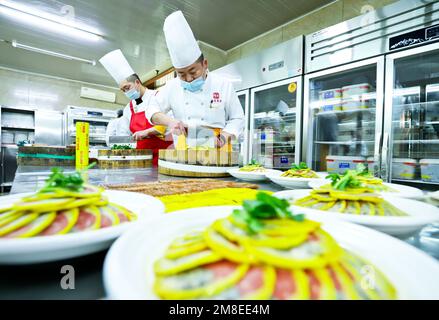 ZHANGYE, CINA - 13 GENNAIO 2023 - gli chef preparano il cenone di Capodanno lunare al Furong Catering Center a Zhangye City, Provincie Gansu della Cina nord-occidentale Foto Stock