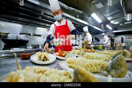 ZHANGYE, CINA - 13 GENNAIO 2023 - gli chef preparano il cenone di Capodanno lunare al Furong Catering Center a Zhangye City, Provincie Gansu della Cina nord-occidentale Foto Stock