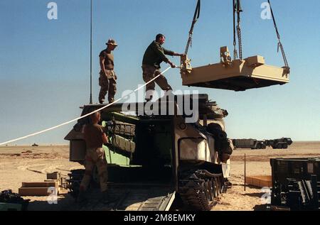 Un Marine assegnato alla Task Force Breach Alpha si trova in cima a un veicolo anfibio d'assalto AAVP-7A1 mentre guida un kit di sminamento Mark 154 in posizione sul veicolo durante l'operazione Desert Storm. I Marines provengono dal Battaglione 2nd Combat Engineer, 2nd Marine Division. Soggetto operativo/Serie: DESERT STORM Paese: Arabia Saudita (SAU) Foto Stock