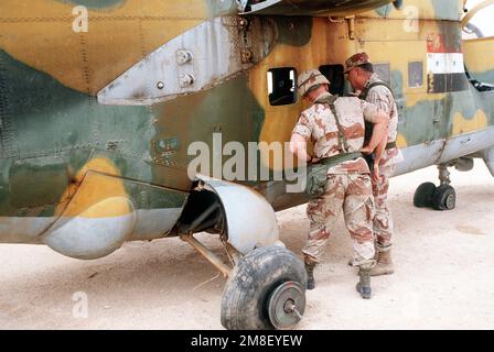 LT. GEN. Gary Luck, comandante generale, XVIII corpo aereo, accompagna GEN. Norman Schwarzkopf, comandante in capo, Stati Uniti Comando Centrale, mentre ispeziona un elicottero iracheno MIL mi-24 Hind catturato durante l'operazione Desert Storm. L'elicottero si trova sul campo di volo presso la base operativa del XVIII corpo aereo presso l'aeroporto di Rahfa. Soggetto operativo/Serie: DESERT STORM Paese: Arabia Saudita (SAU) Foto Stock