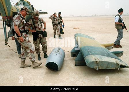 GEN. Norman Schwarzkopf, comandante in capo, Stati Uniti Comando centrale e LT. GEN. Gary Luck, comandante, XVIII corpo di trasporto aereo, ispezionare un contenitore di armi e l'ala ausiliaria di un elicottero iracheno MIL mi-24 Hind catturato durante l'operazione Desert Storm. L'aeromobile è sul campo di volo presso la base operativa del XVIII corpo di trasporto aereo presso l'aeroporto di Rahfa. Soggetto operativo/Serie: DESERT STORM Paese: Arabia Saudita (SAU) Foto Stock