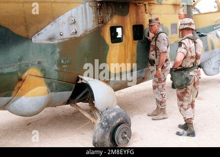 LT. GEN. Gary Luck, comandante generale, XVIII corpo aereo, accompagna GEN. Norman Schwarzkopf, comandante in capo, Stati Uniti Comando Centrale, mentre ispeziona un elicottero iracheno MIL mi-24 Hind catturato durante l'operazione Desert Storm. L'elicottero si trova sul campo di volo presso la base operativa del XVIII corpo aereo presso l'aeroporto di Rahfa. Soggetto operativo/Serie: DESERT STORM Paese: Arabia Saudita (SAU) Foto Stock