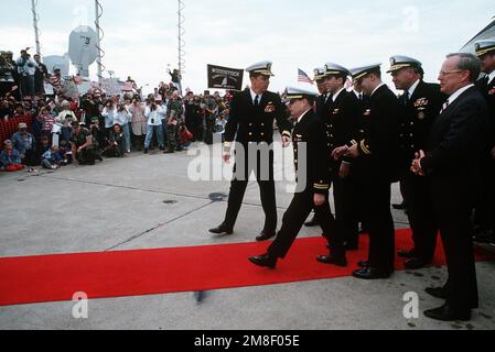 LT. Jeffrey Zaun, secondo da sinistra, conduce LT. Robert Wetzel, quarto da sinistra, e LT. Lawrence Slade su un tappeto rosso durante una cerimonia in loro onore. I tre erano stati detenuti dall'Iraq dopo essere stati abbattuti durante l'operazione Desert Storm. In attesa di unirsi a loro sono posteriore ADM. Paul W. Parcells, sinistra, comandante, Tactical Wings, Atlantic Fleet; DIRETTORE delle operazioni Navali ADM. Frank B. Kelso II, secondo da destra; e Segretario della Marina H. Lawrence Garrett III, a destra. Soggetto operativo/Serie: DESERT STORM base: Naval Air Station, Oceana Stato: Virginia (VA) Paese: Stati Uniti d'America (USA) Foto Stock