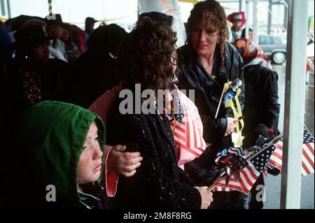 Le famiglie e gli amici dei marinai assegnati alla nave d'assalto anfibio USS NASSAU (LHA-4) si levano dalla pioggia in attesa dell'arrivo della nave. Il NASSAU sta ritornando a Norfolk dopo quasi otto mesi di spiegamento, durante i quali i marinai della nave e imbarcati Marines sono stati coinvolti nell'operazione Sharp Edge in Liberia e nell'operazione Desert Storm nella regione del Golfo Persico. Subject Operation/Series: DESERT STORMSHARP EDGE base: Onslow Bay Stato: North Carolina (NC) Paese: Stati Uniti d'America (USA) Foto Stock