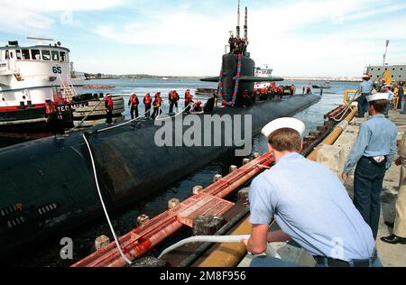 I gestori di linea a riva e a bordo del sottomarino d'attacco nucleare USS CHICAGO (SSN-721) sono in piedi mentre le barche commerciali a rimorchiatore spostano il sottomarino gli ultimi pochi metri fino al molo. La CHICAGO sta ritornando a San Diego dopo il suo dispiegamento nella regione del Golfo Persico per Operation Desert Storm. Soggetto operativo/Serie: DESERT STORM base: Naval Submarine base, San Diego Stato: California (CA) Paese: Stati Uniti d'America (USA) Foto Stock