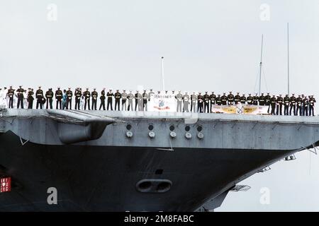 I membri del distaccamento della Marina della nave detengono un banner mentre si trovano a prua della portaerei USS AMERICA (CV-66) durante il suo arrivo alla stazione navale. L'AMERICA sta ritornando a Norfolk dopo il suo spiegamento nella regione del Golfo Persico per l'operazione Desert Shield e l'operazione Desert Storm. Soggetto operativo/Serie: DESERT SHIELD DESERT STORM base: Naval Air Station, Norfolk Stato: Virginia (VA) Paese: Stati Uniti d'America (USA) Foto Stock