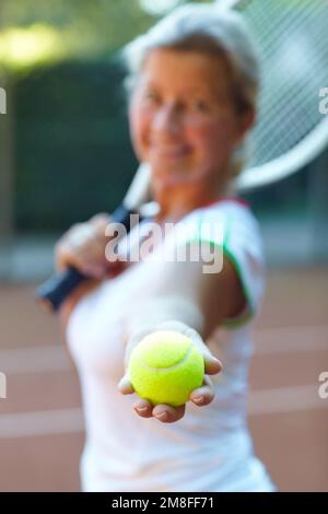 Lascia il gioco. Donna anziana offuscata che ti offre una partita di tennis. Foto Stock