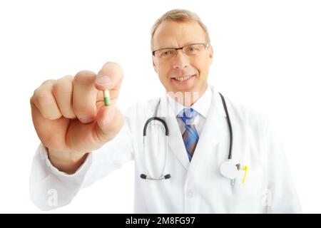 Viso, medico e uomo con pillole in studio isolato su uno sfondo bianco. Ritratto, assistenza sanitaria e felice operatore medico, farmacista e maschio maturo Foto Stock