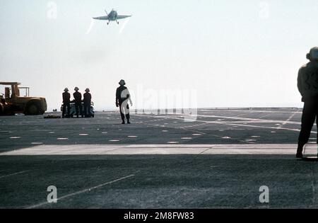 Gli equipaggi di arresto a bordo della portaerei USS MIDWAY (CV-41) guardano come un aereo Strike Fighter Squadron 151 (VFA-151) F/A-18A Hornet volato da CAPT Patrick D. Moneymaker, il comandante di Carrier Air Wing 14 (CVW-14), fa un passaggio sul ponte di volo prima di venire in giro per un atterraggio arrestato. L'atterraggio di Moneymaker sarà l'ultimo fatto a bordo della STRADA INTERMEDIA prima della sua disattivazione nella primavera del 1992. Paese: Oceano Pacifico (POC) Foto Stock