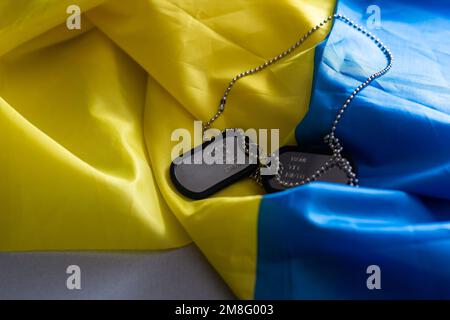 Tag ID militare e bandiera Ucraina sullo sfondo. Design del banner Foto Stock