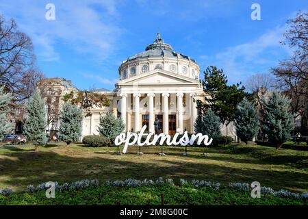 Bucarest, Romania, 2 gennaio 2022: Parola ottimista visualizzata di fronte al rumeno Atheneum Ateneul romano), edificio circolare che è la conce principale Foto Stock