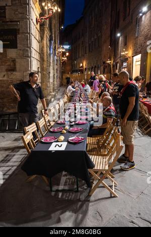 Siena, Italia - 15 2022 agosto: La cena in Grande Contrada del Civetta o piccola gufo Contrada la sera prima del Palio dell'Assunta in Piazza To Foto Stock