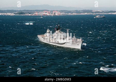 Una vista di prua a dritta della nave di comando anfibia USS BLUE RIDGE (LCC-19) in corso vicino al suo porto di casa degli Stati Uniti Stazione navale di Yokosuka, Giappone. Un sottomarino è in corso sulla superficie dietro la CRESTA BLU. Base: Tokyo Bay Paese: Giappone (JPN) Foto Stock