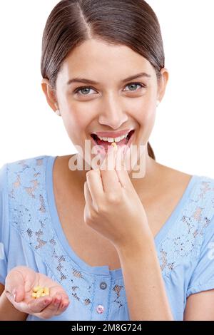 Ritratto, pillole e medicina con una donna modello in studio isolato su uno sfondo bianco per vitamine o integratori. Medico, salute e tablet con Foto Stock