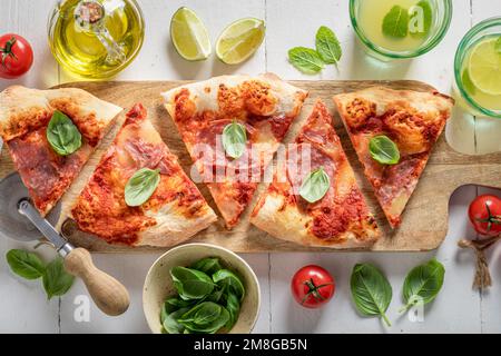 Pizza deliziosa e calda con ingredienti freschi. Pizza tradizionale italiana. Pizza a base di prosciutto e formaggio. Foto Stock