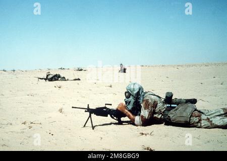 Un mitragliatore indossa una maschera a gas M-17 mentre si allera con un'arma automatica M-249 durante un esercizio di guerra nucleare-biologico-chimica, parte dell'operazione Desert Shield. Subject Operation/Series: SCUDO DEL DESERTO Paese: Arabia Saudita (SAU) Foto Stock