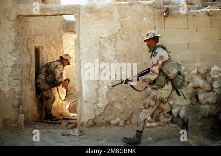 Soldati di Co.. A, 3rd BN., 502nd INF. Regt., 101st Airborne Div., utilizza una città abbandonata per eseguire un allenamento di guerra urbana durante l'operazione Desert Shield. Il soldato in primo piano è armato di un fucile M-16A2. Subject Operation/Series: SCUDO DEL DESERTO Paese: Arabia Saudita (SAU) Foto Stock