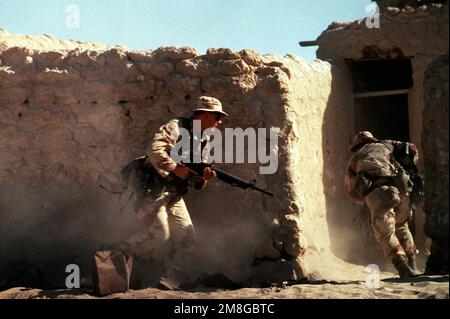 Soldati di Co.. A, 3rd BN., 502nd INF. Reg., immettere un composto in una città abbandonata. Gli uomini, armati di fucili M-16A2, partecipano a un allenamento di guerra urbano durante l'operazione Desert Shield. Subject Operation/Series: SCUDO DEL DESERTO Paese: Arabia Saudita (SAU) Foto Stock