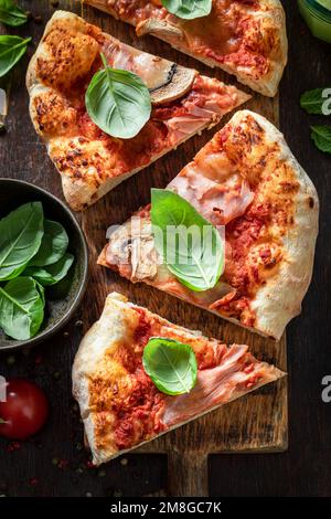 Pizza Capricciosa fatta in casa su tavolo di legno. Cucina italiana classica. Pizza Capricciosa a base di ingredienti freschi. Foto Stock